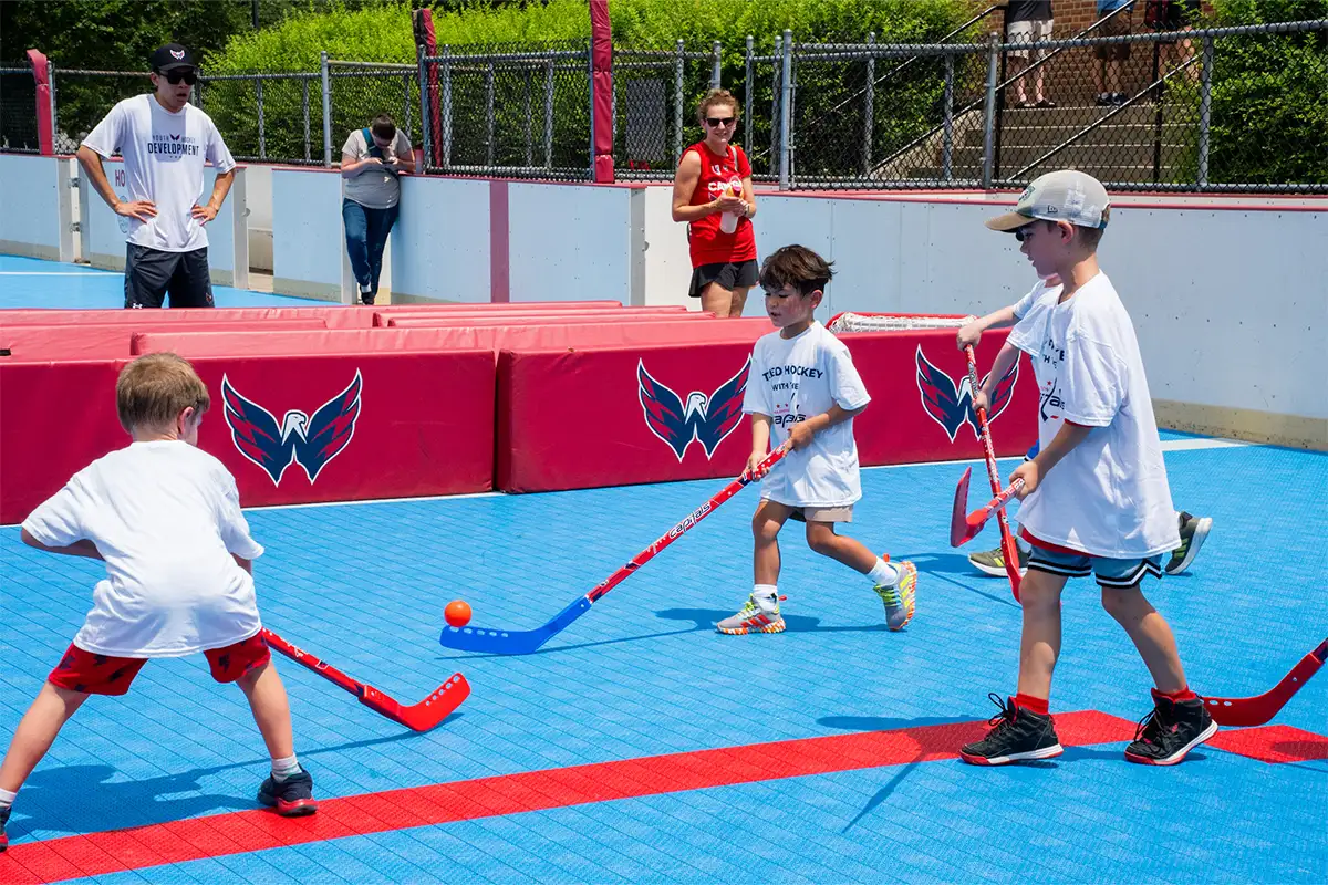 kids play street hockey on a court with Washington Capitals logos
