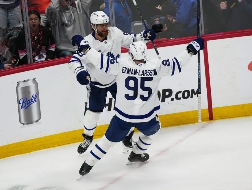 Toronto Maple Leafs defenceman Oliver Ekman-Larsson, front, congratulates right wing William Nylander after he scored the winning goal in overtime of an NHL hockey game against the Colorado Avalanche Monday, Jan. 12, 2026, in Denver.