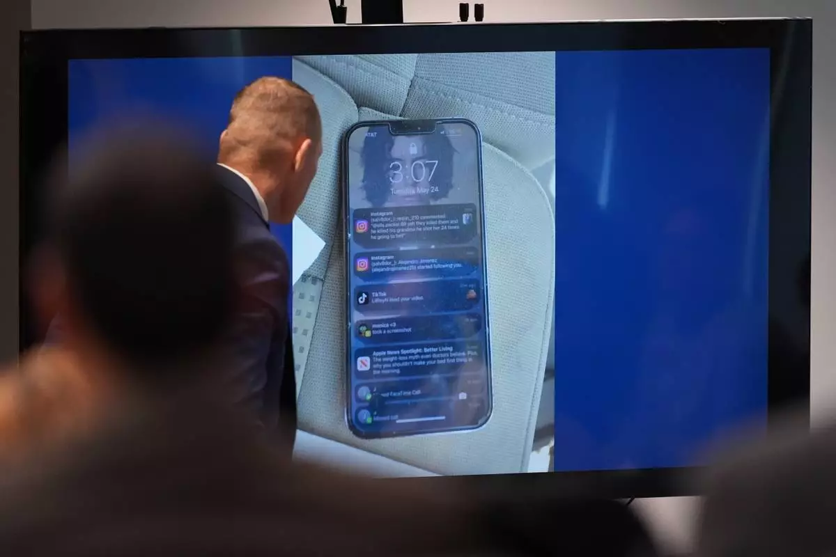 Texas Ranger detective Jason Shea looks at photos of a phone as he gives testimony during a trial for former Uvalde school district police officer Adrian Gonzales at the Nueces County Courthouse in Corpus Christi, Texas, Tuesday, Jan. 6, 2026. (AP Photo/Eric Gay)