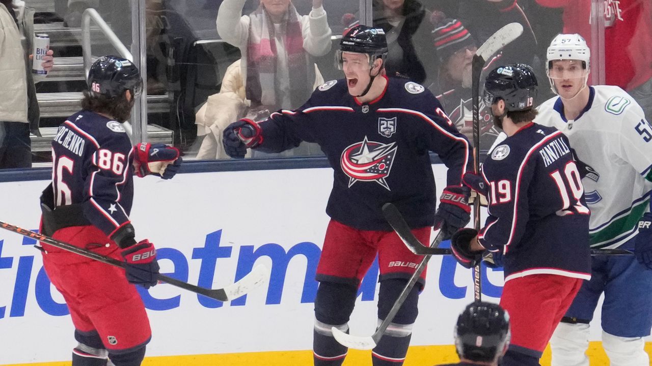 Columbus Blue Jackets center Charlie Coyle, center, celebrates his goal with teammates Kirill Marchenko (86), Adam Fantilli (19) and Zach Werenski (8) in front of Vancouver Canucks defenseman Tyler Myers (57) in the first period of an NHL hockey game Thursday, Jan. 15, 2026, in Columbus, Ohio. (AP Photo/Sue Ogrocki)