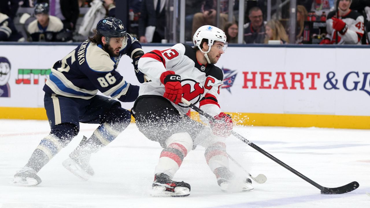 New Jersey Devils forward Nico Hischier, right, controls the puck in front of Columbus Blue Jackets forward Kirill Marchenko during the second period of an NHL hockey game in Columbus, Ohio, Wednesday, Dec. 31, 2025. (AP Photo/Paul Vernon)