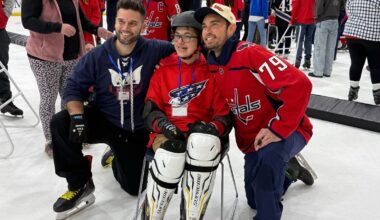 Goalkeeper Charlie Lindgren poses with a kid on the ice