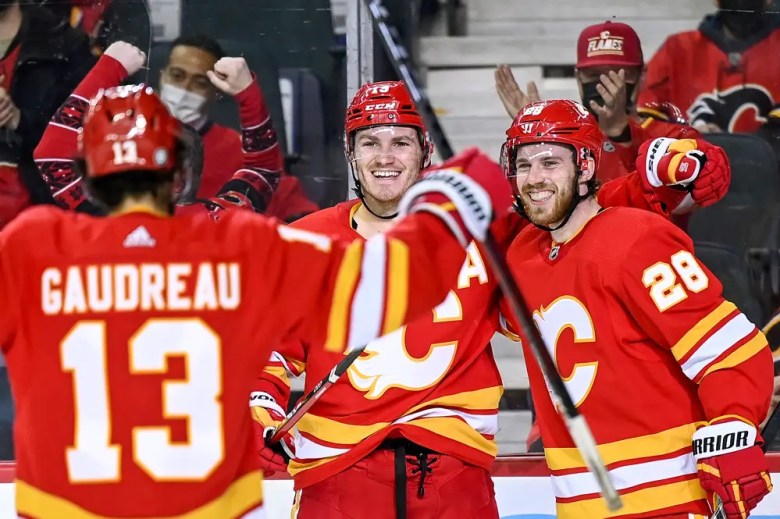 CALGARY, AB - JANUARY 18: Calgary Flames Right Wing Matthew Tkachuk (19) celebrates a goal with Calgary Flames Left Wing Johnny Gaudreau (13) and Calgary Flames Center Elias Lindholm (28) during the third period of an NHL game where the Calgary Flames hosted the Florida Panthers on January 18, 2022, at the Scotiabank Saddledome in Calgary, AB. (Photo by Brett Holmes/Icon Sportswire)