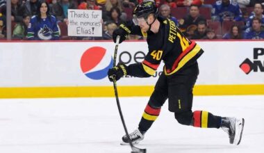 Elias Pettersson (#40) of the Vancouver Canucks, wearing his black "Flying V" jersey, winds up for a slapshot on the ice. Behind him, a female fan with dark hair stands in the front row behind the glass, holding a white sign with handwritten black text that reads, "Thanks for the memories Elias!". Other fans fill the red seats in the background.