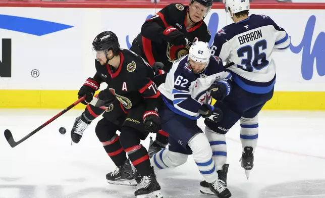 Ottawa Senators' Thomas Chabot (72), Winnipeg Jets' Nino Niederreiter (62), Senators' Brady Tkachuk (7) and Jets' Morgan Barron (36) battle for the puck during the second period of an NHL hockey game in Ottawa, Ontario, on Saturday, Jan. 3, 2026. (Patrick Doyle/The Canadian Press via AP)