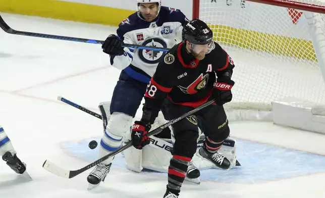Winnipeg Jets' Dylan DeMelo (2) and Ottawa Senators' Claude Giroux (28) battle in front of the net during the second period of an NHL hockey game in Ottawa, Ontario, on Saturday, Jan. 3, 2026. (Patrick Doyle/The Canadian Press via AP)