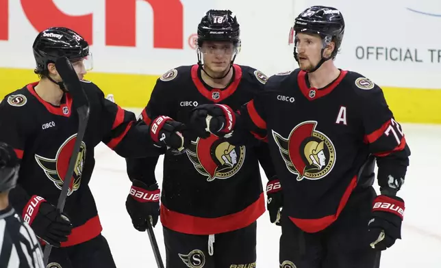 Ottawa Senators' Thomas Chabot, right, celebrates his goal with teammates Tim Stutzle, center, and Dylan Cozens (24) during the first period of an NHL hockey game against the Winnipeg Jets in Ottawa, Ontario, Saturday, Jan. 3, 2026. (Patrick Doyle/The Canadian Press via AP)