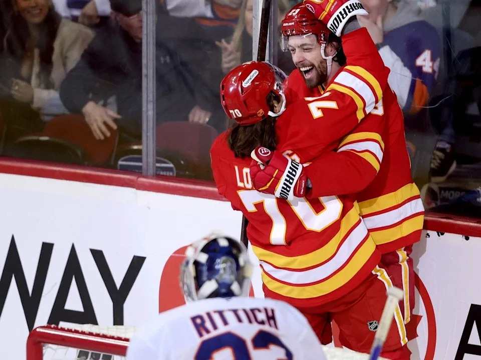Flames forward Justin Kirkland (back) celebrates his goal against the Islanders with Ryan Lomberg.
