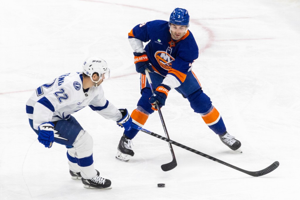 New York Islanders defenseman Adam Pelech (3) moves the puck down ice as Tampa Bay Lightning right wing Oliver Bjorkstrand (22) defends during the first period at UBS Arena, Saturday, Dec. 13, 2025, in Elmont, NY. 