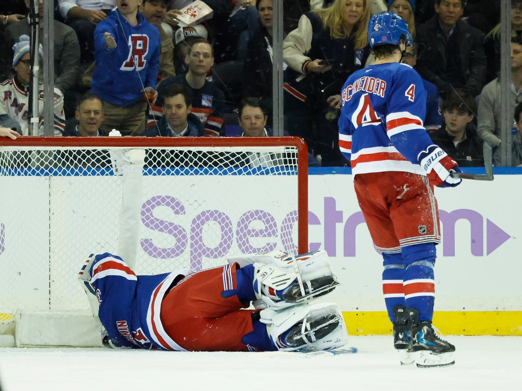 New York Rangers goaltender Igor Shesterkin lays on the ice in front of the goal after falling back on his leg in a game against the Utah Mammoth.