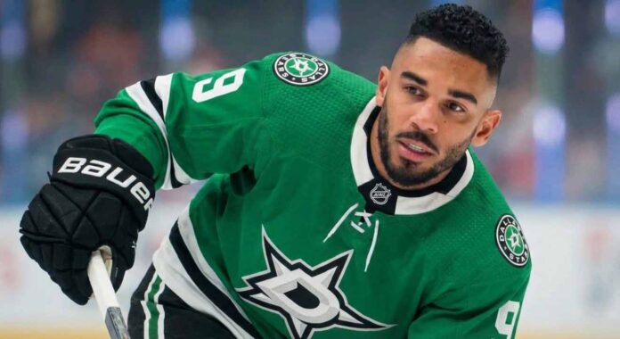 NHL player Evander Kane wearing a green victory Dallas Stars home jersey with the number 9, holding his stick on the ice and looking towards the right side of the frame.