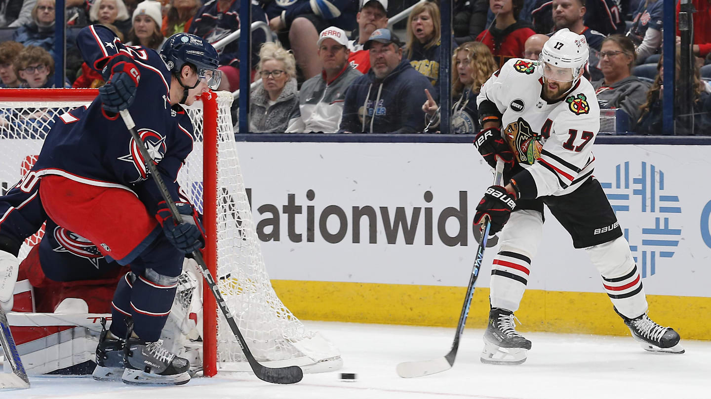 Nov 22, 2023; Columbus, Ohio, USA; Chicago Blackhawks leftt wing Nick Foligno (17) passes the puck as Columbus Blue Jackets defenseman Jake Bean (22) defends during the second period at Nationwide Arena. Mandatory Credit: Russell LaBounty-Imagn Images