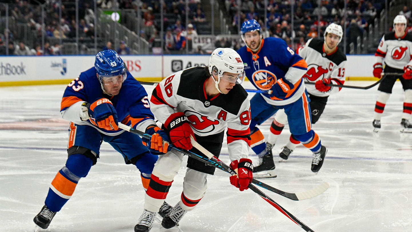 Jan 6, 2026; Elmont, New York, USA;  New York Islanders center Casey Cizikas (53) defends against New Jersey Devils center Jack Hughes (86) during the third period at UBS Arena. Mandatory Credit: Dennis Schneidler-Imagn Images