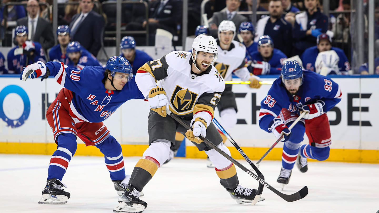 Feb 2, 2025; New York, New York, USA; Vegas Golden Knights defenseman Shea Theodore (27) skates through traffic with the puck as New York Rangers left wing Artemi Panarin (10) defends during the third period at Madison Square Garden. Mandatory Credit: Danny Wild-Imagn Images