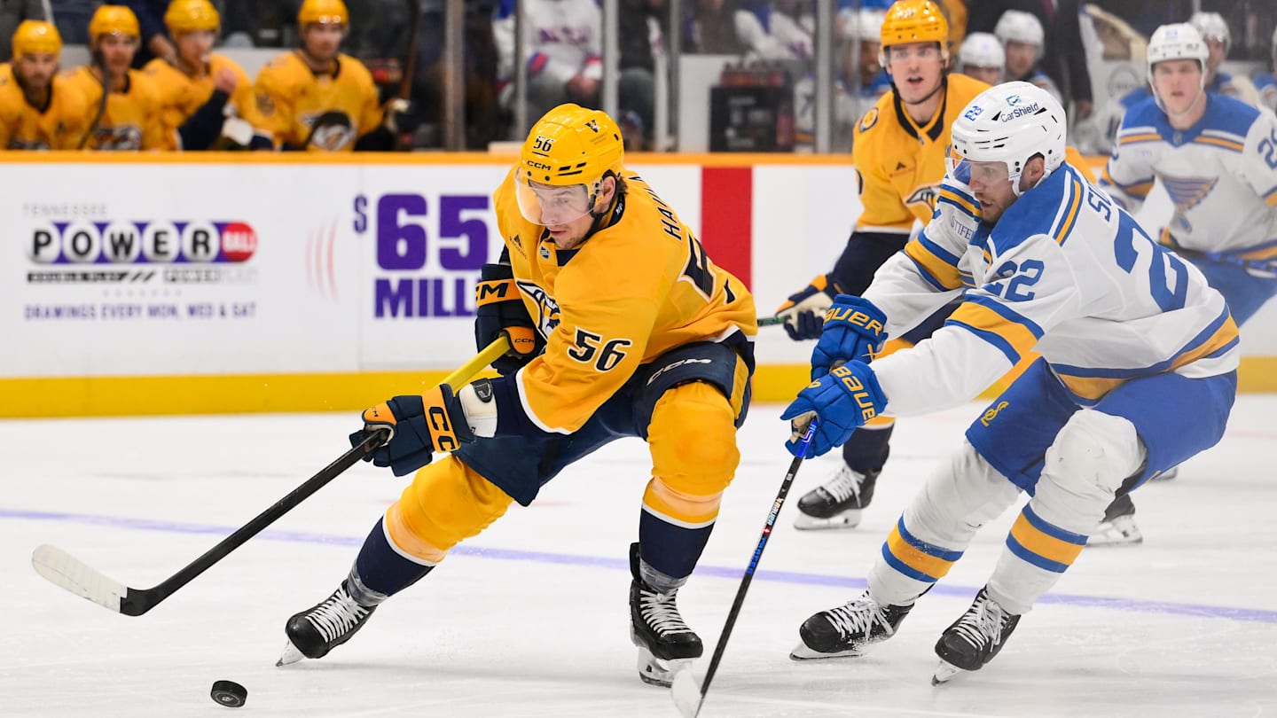 Feb 2, 2026; Nashville, Tennessee, USA;  Nashville Predators left wing Erik Haula (56) and St. Louis Blues center Pius Suter (22) battle for the puck during the first period at Bridgestone Arena. Mandatory Credit: Steve Roberts-Imagn Images