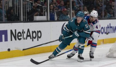 Jan 23, 2026; San Jose, California, USA;  San Jose Sharks right wing Collin Graf (51) and New York Rangers defenseman Braden Schneider (4) fight for control of the puck during the second period at SAP Center at San Jose. Mandatory Credit: Stan Szeto-Imagn Images