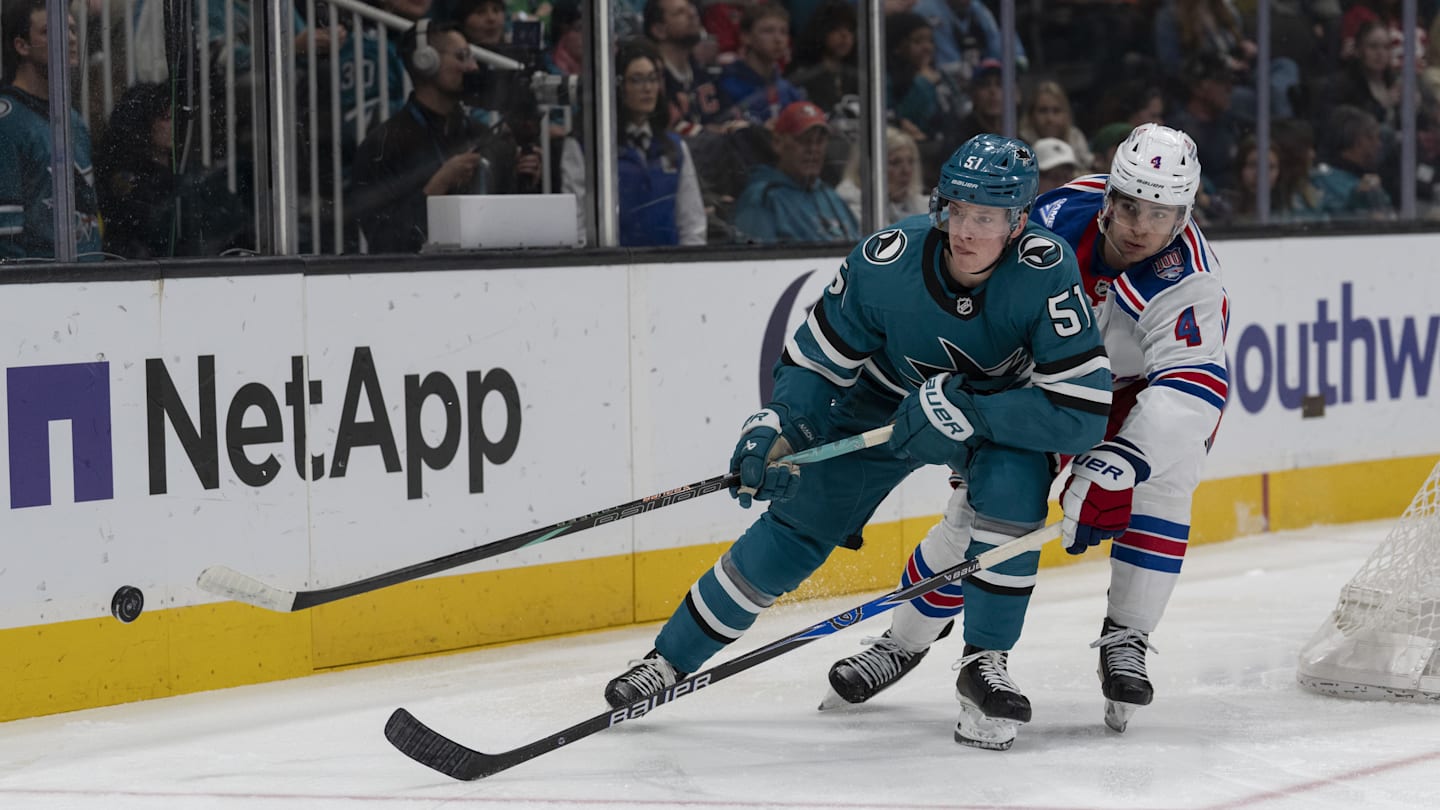 Jan 23, 2026; San Jose, California, USA;  San Jose Sharks right wing Collin Graf (51) and New York Rangers defenseman Braden Schneider (4) fight for control of the puck during the second period at SAP Center at San Jose. Mandatory Credit: Stan Szeto-Imagn Images