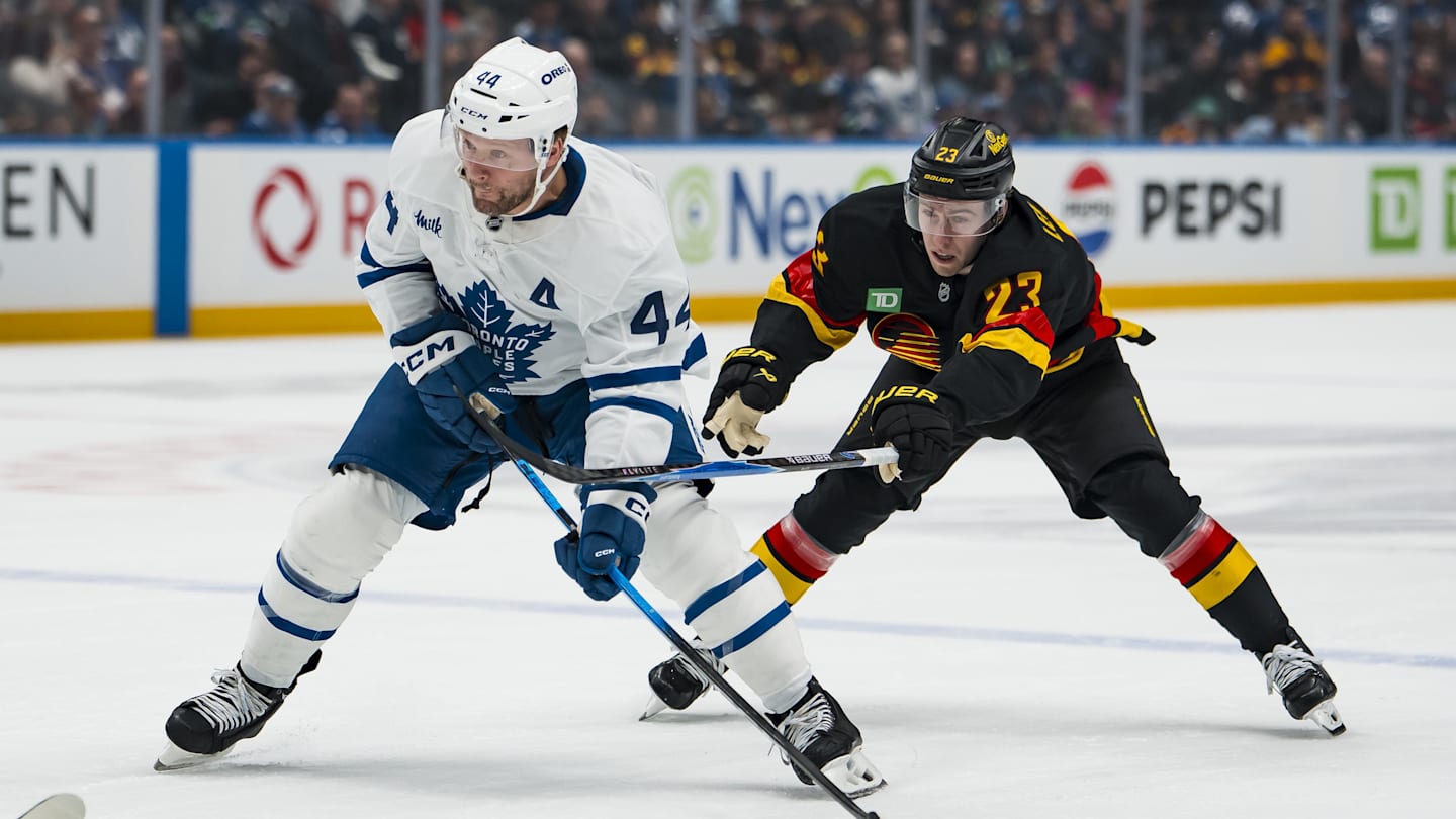 Jan 31, 2026; Vancouver, British Columbia, CAN; Vancouver Canucks forward Jonathan Lekkerimaki (23) stick checks Toronto Maple Leafs defenseman Morgan Rielly (44) in the first period at Rogers Arena. Mandatory Credit: Bob Frid-Imagn Images