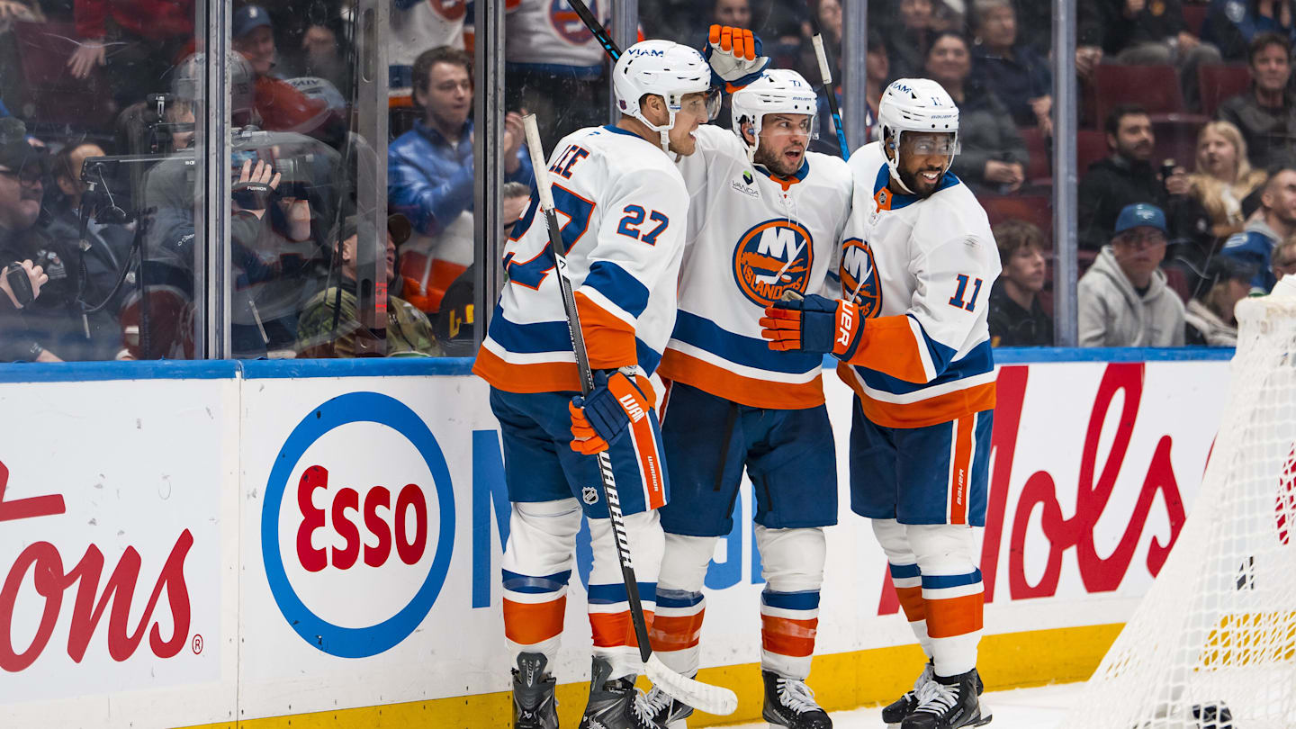 Jan 19, 2026; Vancouver, British Columbia, CAN; New York Islanders defenseman Tony DeAngelo (77) celebrates with forwards Anthony Duclair (11) and Anders Lee (27) after scoring a goal against the Vancouver Canucks in the third period at Rogers Arena. Mandatory Credit: Bob Frid-Imagn Images
