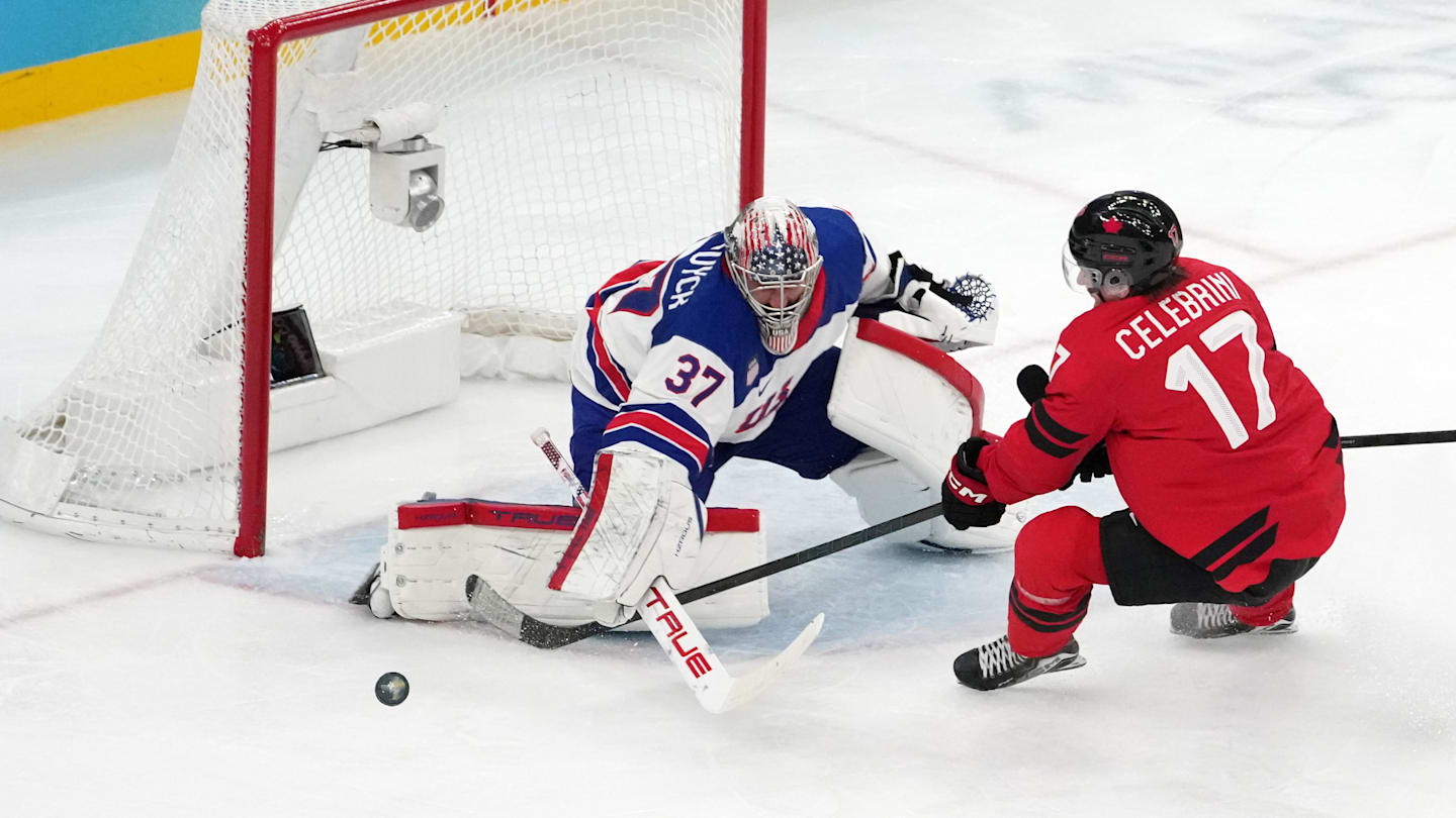 Feb 22, 2026; Milan, Italy; Connor Hellebuyck of the United States battles for the puck against Macklin Celebrini of Canada during the men's ice hockey gold medal game during the Milano Cortina 2026 Olympic Winter Games at Milano Santagiulia Ice Hockey Arena. Mandatory Credit: James Lang-Imagn Images