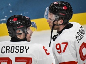 Canada's Sidney Crosby speaks with Connor McDavid as they celebrate their win over Czechia at the Milano-Cortina 2026 Winter Olympic Games.