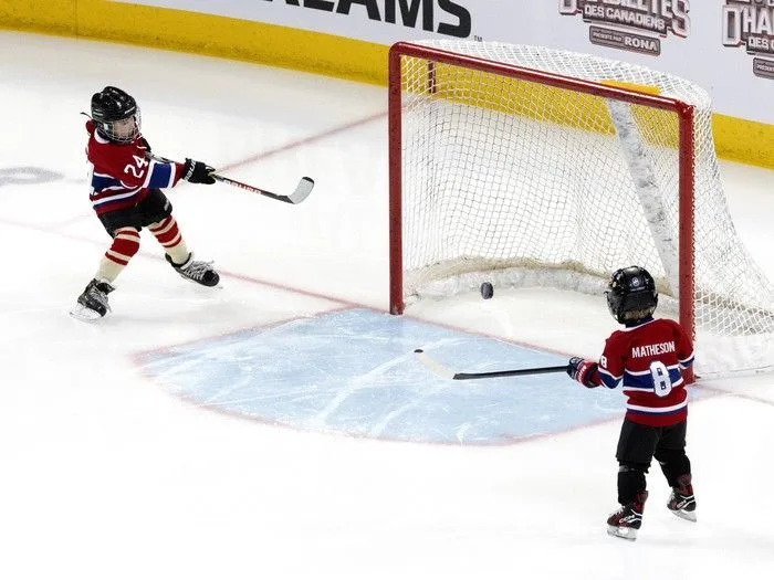  Phillip-Édouard Danault, left, and Hudson Matheson take shots on the net as their fathers compete in the Montreal Canadiens’ skills competition at the Bell Centre on Sunday, February 22, 2026.