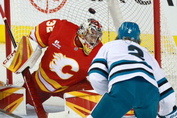 San Jose Sharks' Will Smith (2) scores on Calgary Flames goalie Dustin Wolf during the first period of an NHL hockey games in Calgary, Saturday, Jan. 31, 2026. (Larry MacDougal/The Canadian Press via AP)