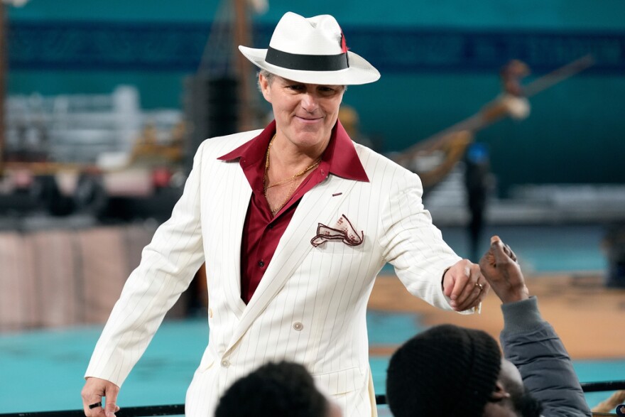 Tampa Bay head coach Jon Cooper, wearing a white suit as a "tip of the hat" to Tampa's heritage, walks to the bench before the start of the third period of the NFL Stadium Series on Feb. 1, 2026, in Tampa.