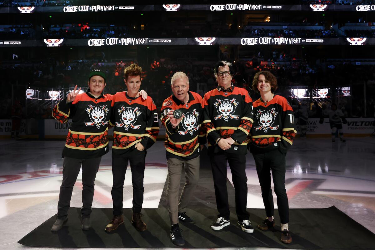 Members of the band the Offspring pose for a photo during a pre-game puck ceremony 