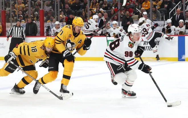 Jan 29, 2026; Pittsburgh, Pennsylvania, USA; Chicago Blackhawks center Connor Bedard (98) skates with the puck ahead of Pittsburgh Penguins center Tommy Novak (18) and center Evgeni Malkin (71) during the second period at PPG Paints Arena.
