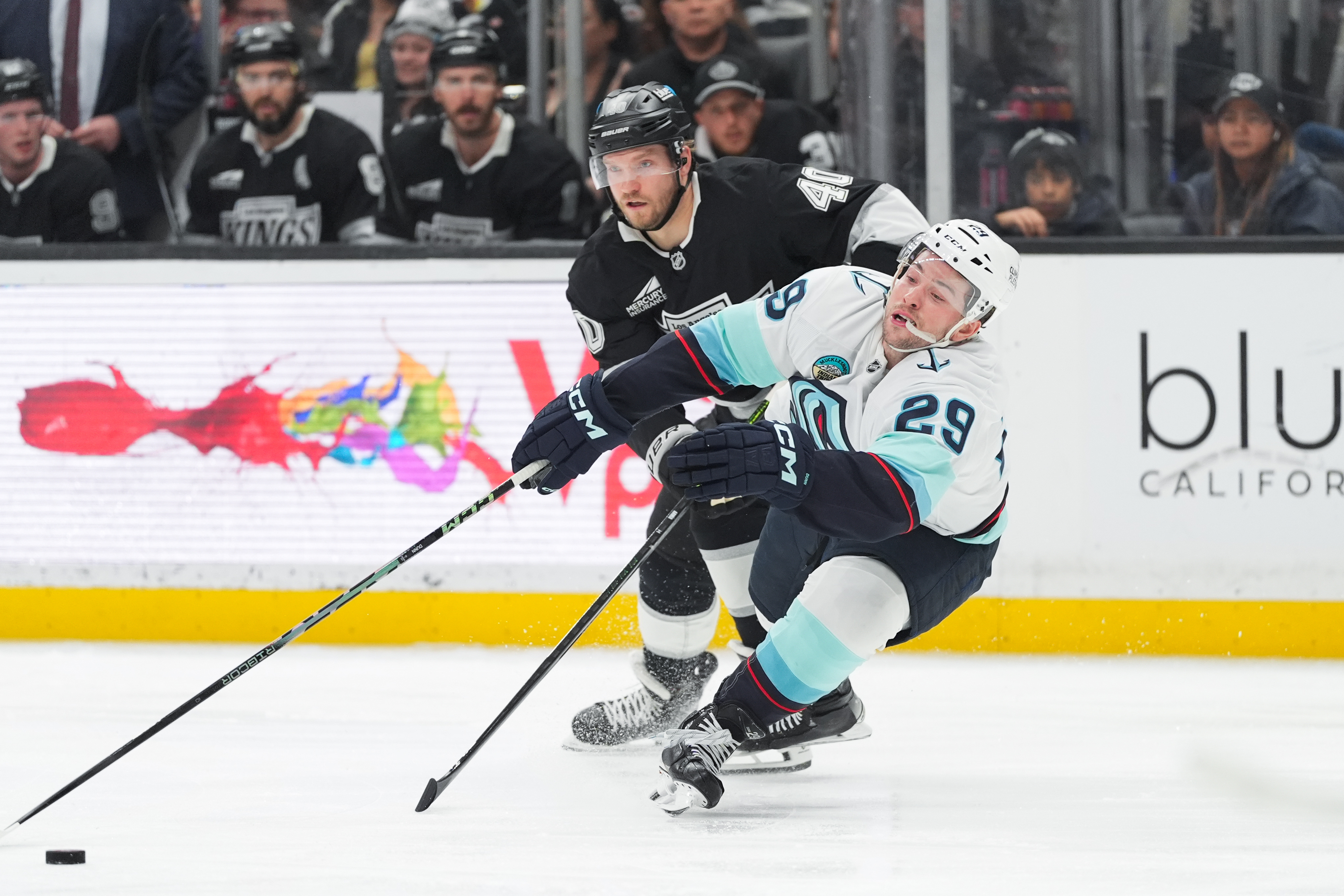 Seattle Kraken defenseman Vince Dunn, right, loses balance as he...