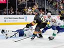 Cole Reinhardt #23 of the Vegas Golden Knights scores a goal against Kevin Lankinen of the Vancouver Canucks as Max Sasson of the Canucks defends in the second period of their game at T-Mobile Arena on February 04, 2026 in Las Vegas, Nevada.