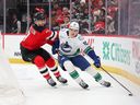 Winger Liam Ohgren of the Vancouver Canucks makes power move to fend off defenceman Dougie Hamilton of the New Jersey Devils on Dec. 14 in Newark, N.J.