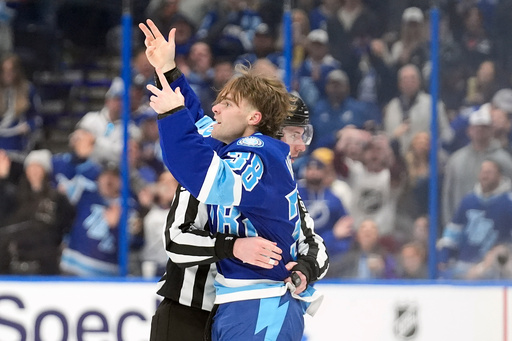 Tampa Bay Lightning left wing Brandon Hagel (38) waves to the crowd as he heads to the penalty box after fighting Florida Panthers left wing Matthew Tkachuk during the third period of an NHL hockey game Thursday, Feb. 5, 2026, in Tampa, Fla. (AP Photo/Chris O