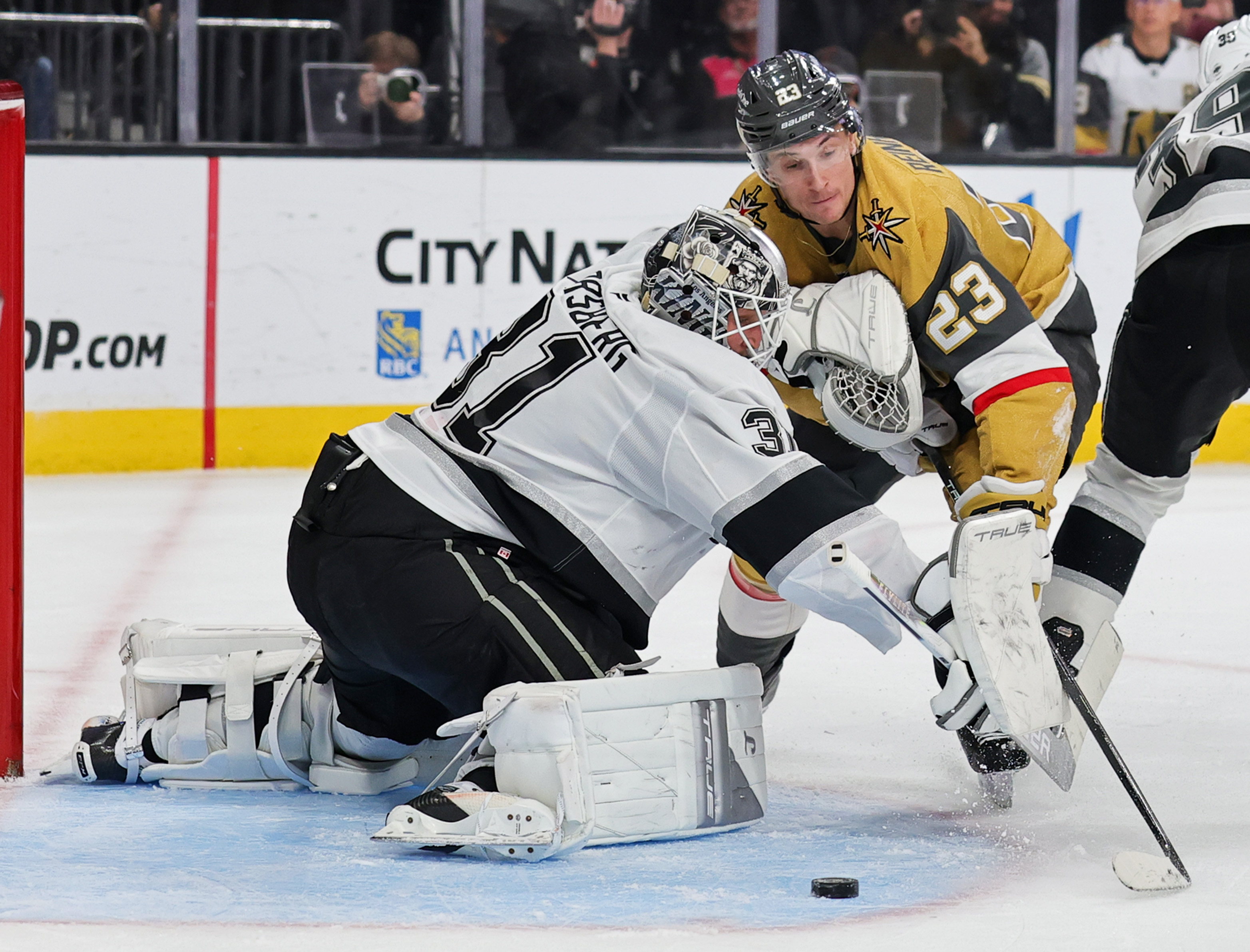 Kings goaltender Anton Forsberg, left, defends the net against the...