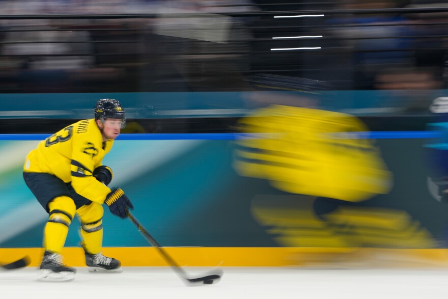 Sweden's Lucas Raymond controls the puck during a preliminary round match of men's ice hockey between Finland and Sweden at the 2026 Winter Olympics, in Milan, Italy, Friday, Feb. 13, 2026. (AP Photo/Hassan Ammar)
