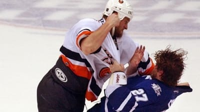 The Islanders' Eric Cairns, left, fights with Toronto's Shayne Corson in...