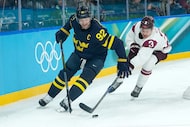 Sweden's Gabriel Landeskog (92) is challenged by Latvia's Alberts Smits (3) during a men's...