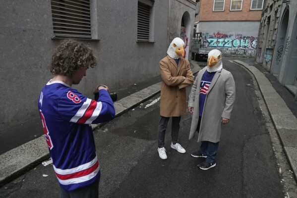 Ryan Winn films Casey Winn and Mitchell Hanson in a promotional video for the Winn's sister, Haley Winn, and the rest of the USA women's hockey team, Thursday, Feb. 19, 2026, in Milan, Italy. (AP Photo/Brittany Peterson)