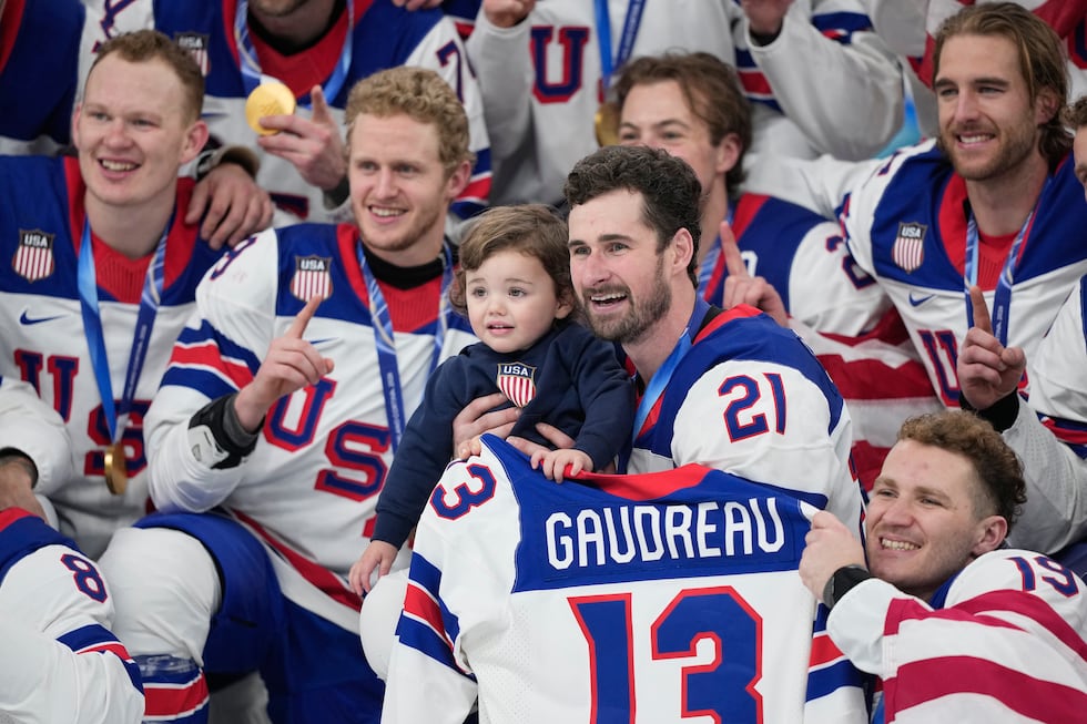 United States' Dylan Larkin (21) holds Johnny, the son of the late player Johnny Gaudreau,...