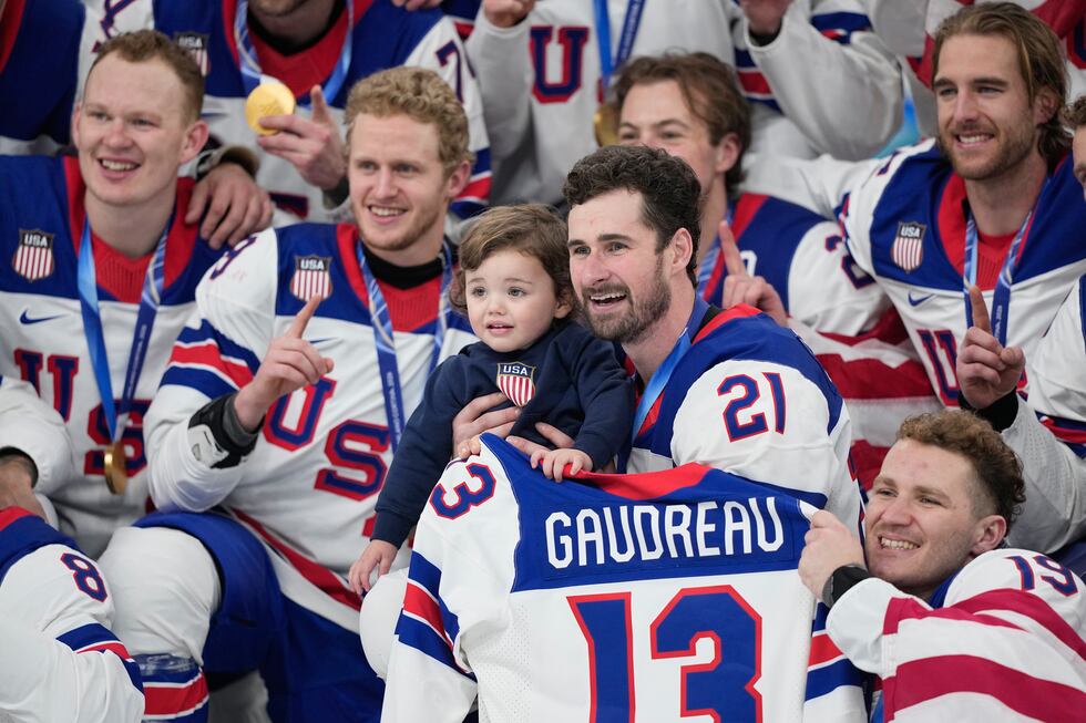 United States' Dylan Larkin (21) holds Johnny, the son of the late player Johnny Gaudreau,...