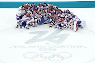 United States players pose for pictures after their win over Canada in the men's ice hockey...