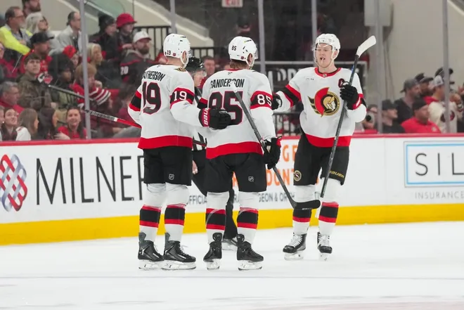 Feb 3, 2026; Raleigh, North Carolina, USA; Ottawa Senators defenseman Jake Sanderson (85) celebrates his goal with right wing Drake Batherson (19) and left wing Brady Tkachuk (7) against the Carolina Hurricanes during the third period at Lenovo Center.