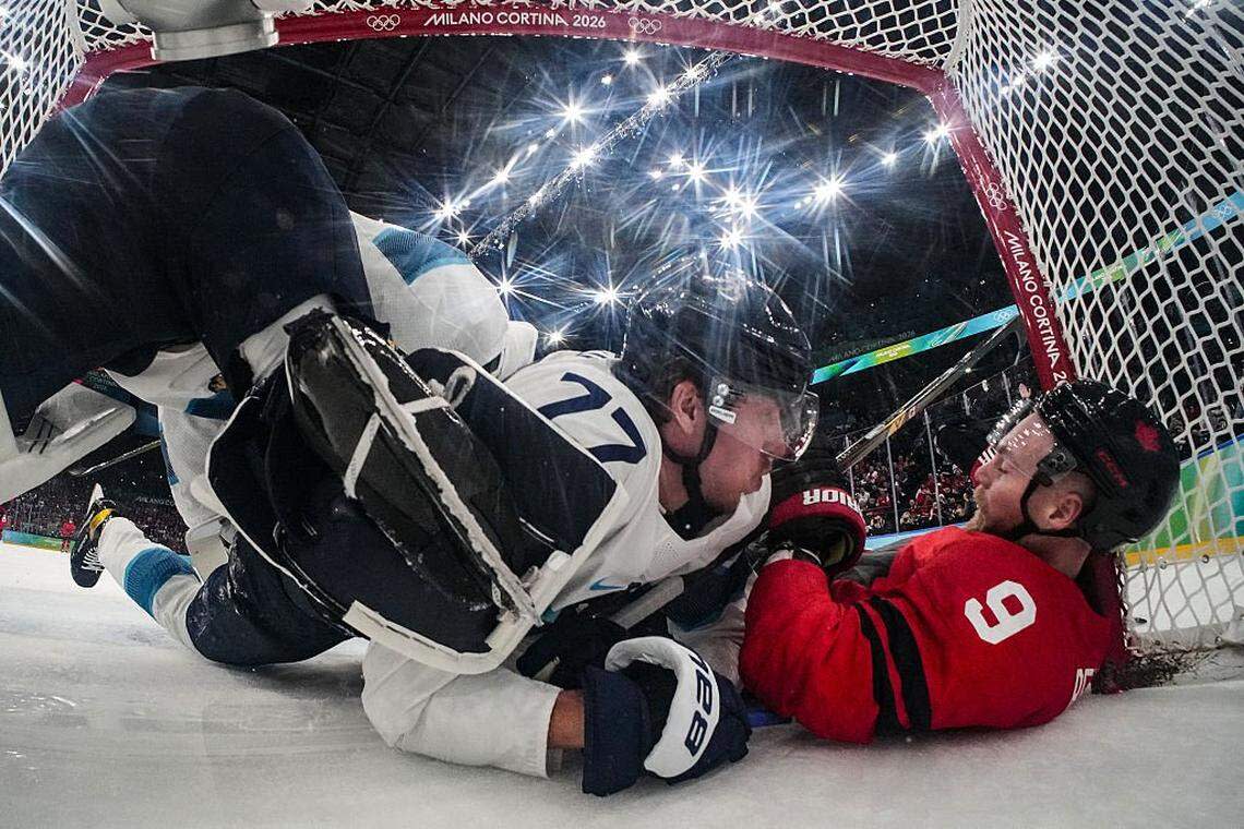 Canada's #09 Sam Bennett (R) and Finland's #77 Niko Mikkola (C) fall into the goal during the men's play-off semi-final ice hockey match between Canada and Finland at the Milano Santagiulia Ice Hockey Arena during the Milano Cortina 2026 Winter Olympic Games in Milan, on February 20, 2026.