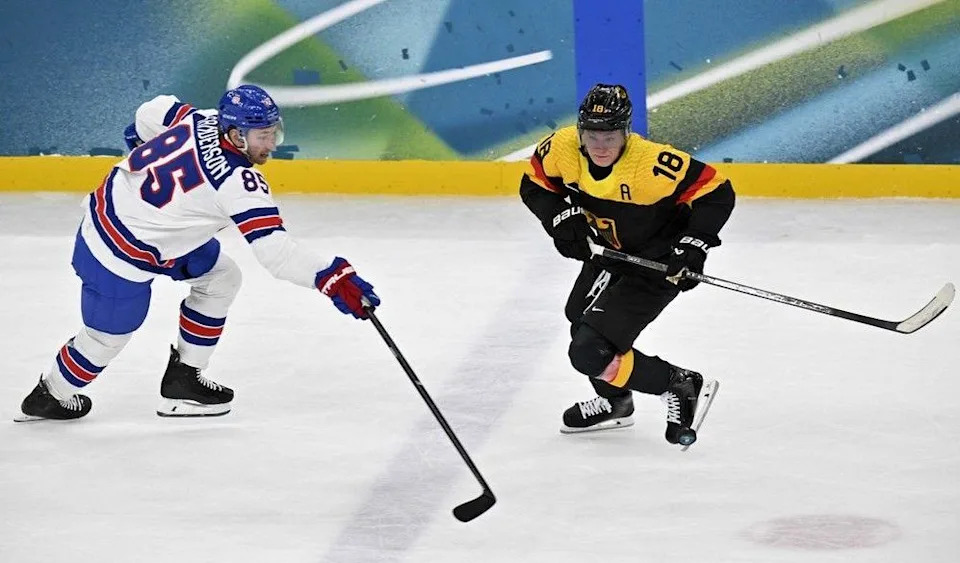  Jake Sanderson of Team USA and Germany’s Tim Stutzle vie for the puck on Sunday, Feb. 15 in Milan.