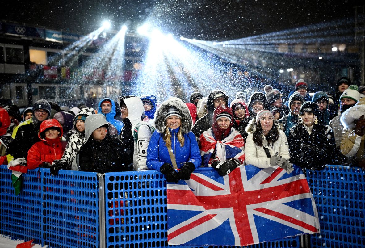 Spectators wait as the women's freestyle skiing big air finals are delayed due to heavy snow on February 16.