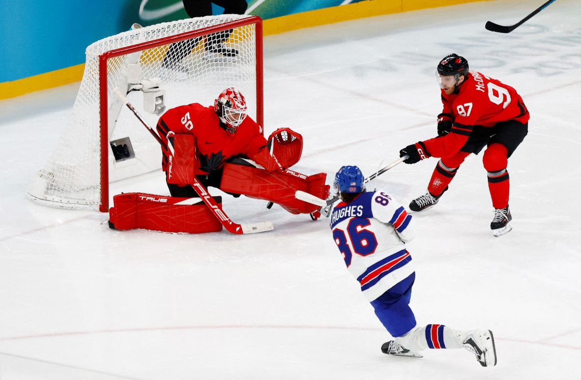 Hughes zips the puck past Canada goalie Jordan Binnington in overtime. Team USA won 2-1.