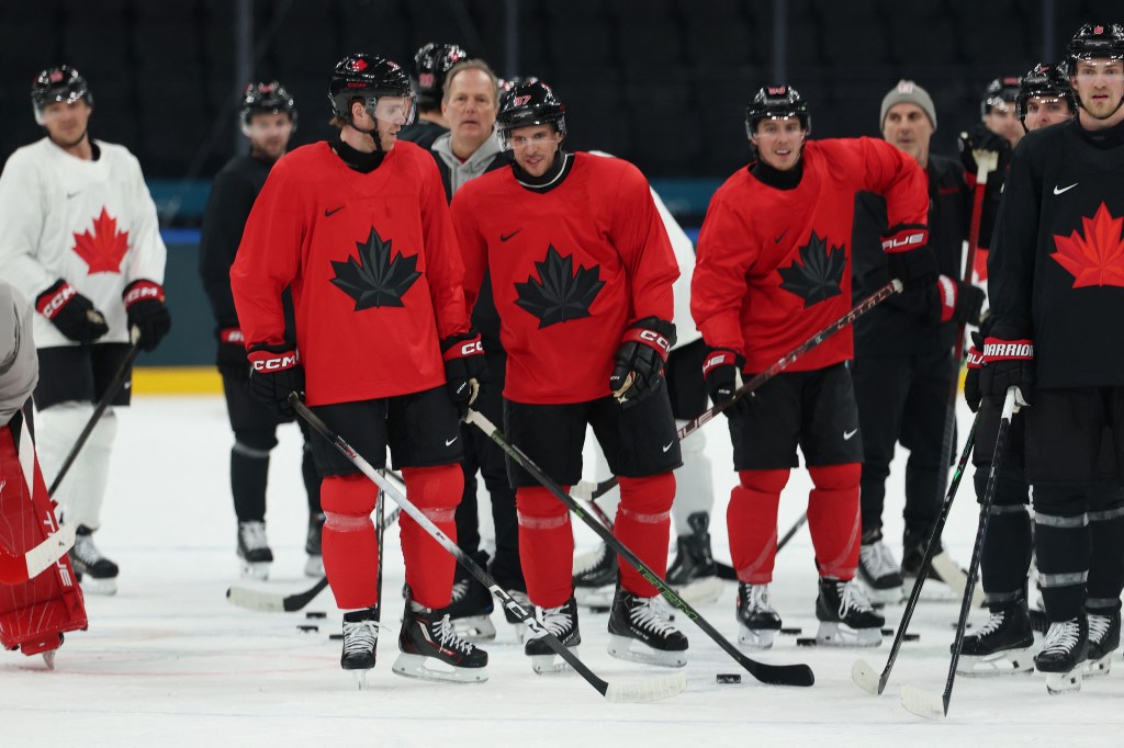 Connor McDavid and Sidney Crosby of Canada in red jerseys with a black maple leaf during ice hockey training.