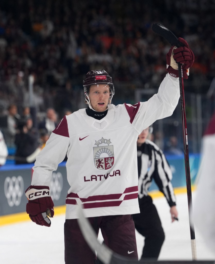 Dans Locmelis celebrates during Latvia's win over Germany at the 2026 Olympics on Feb. 14, 2026. 