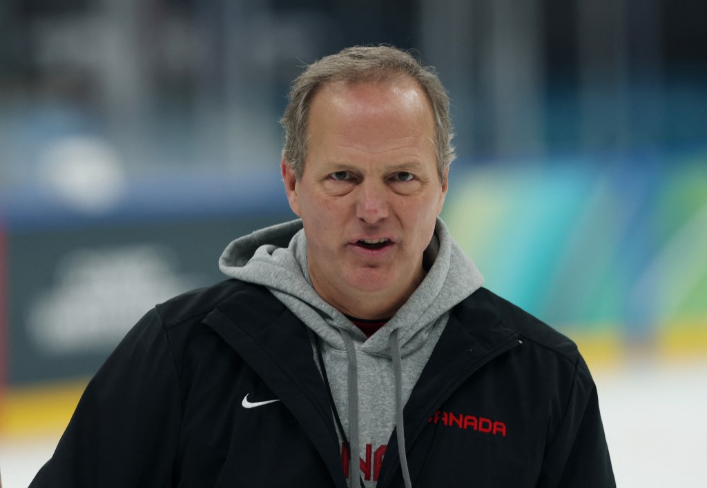 Jon Cooper, head coach of Canada, wearing a black jacket over a grey hoodie, looks forward.